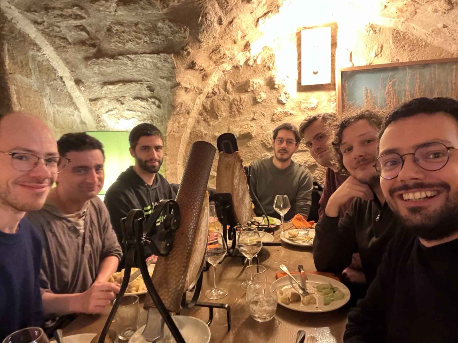 Un groupe de 7 personnes autour d'une table de restaurant avec de la raclette traditionnelle